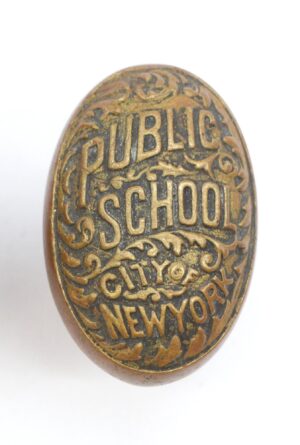 Oval antique bronze doorknob embossed with PUBLIC SCHOOL and CITY OF NEW YORK lettering.