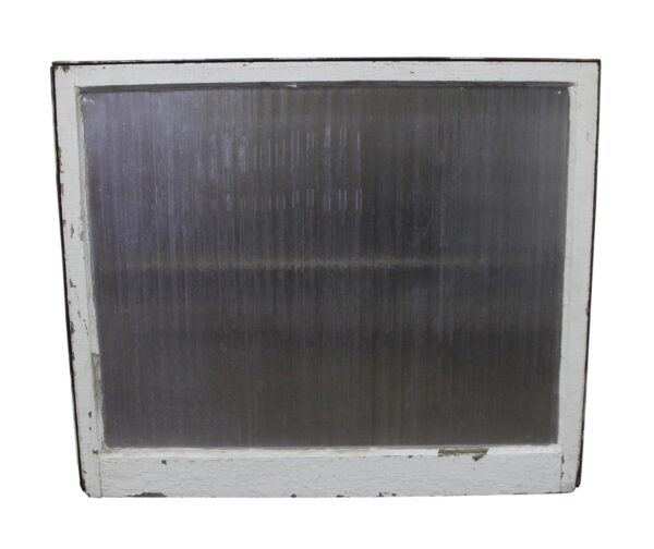 Vintage window with a painted white wood frame and original rippled clear glass.