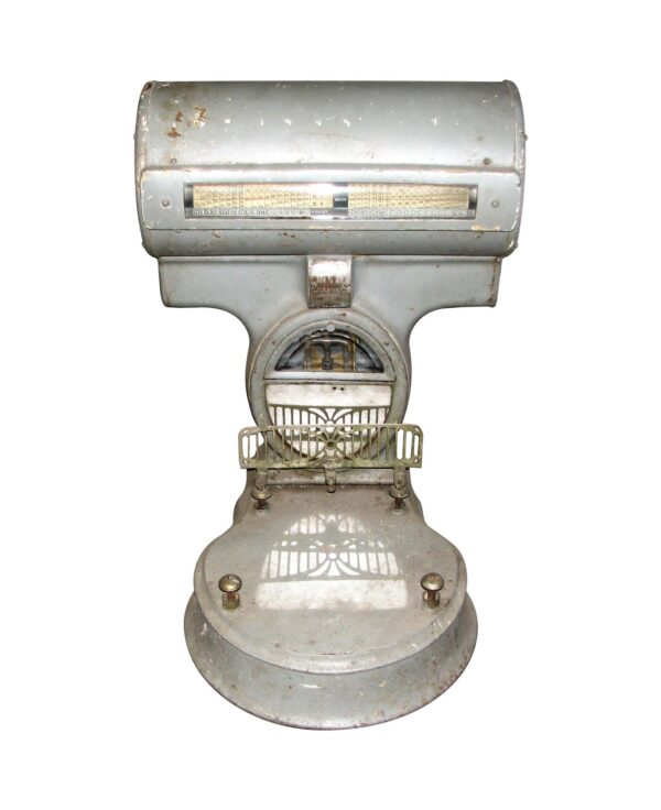 Front view of a gray enamel over metal meat scale with an ornate nickel and brass body, beveled glass side window, and missing scale pan.