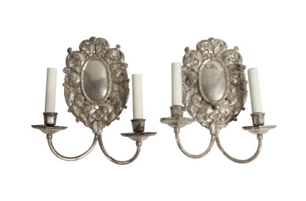 Pair of silvered brass two-arm wall sconces with ornate Louis XV Rococo floral and foliage detailing.