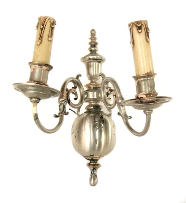 Colonial two-arm wall sconce with a silver finish and two candle holders shown front view.