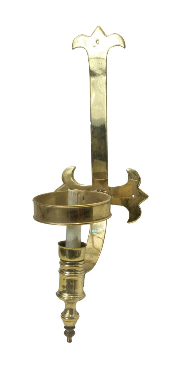 Ecclesiastical brass wall sconce with a polished finish, shown without a shade and featuring a decorative backplate and candle holder.