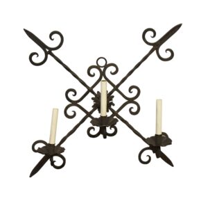 Arts and Crafts wrought iron three-arm wall sconce with black scrollwork arms and three candle holders.