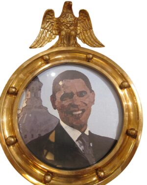Circular brass wall sconce with an eagle motif above a round framed image and rivet details around the edge.