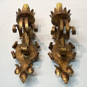 A pair of Gothic wall sconces in gilt wrought iron with leaf-like tops, curled side arms, and pointed lower ends.