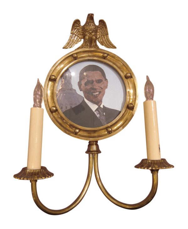 Federal-style brass two-light wall sconce with a circular picture frame, eagle motif, and two candle arms.