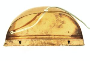 Copper-plated dome wall sconce with visible cord and keyhole mounting slots, shown in a close-up of the back side.