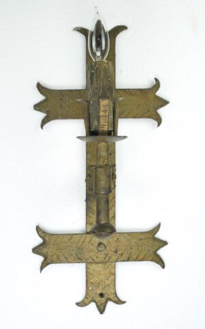 Spanish Revival wall sconce with an antique bronze finish and one bulb socket shown in close-up.