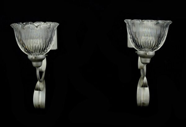 Pair of silver steel wall sconces with clear ruffled holophane glass shades, shown as a left and right pair.