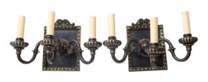 Pair of Tudor-style two-arm wall sconces with two candle-shaped bulbs each, shown as a matching set with ornate backplates and black and gold finish.