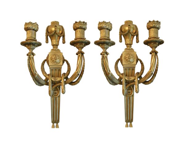 Pair of French bronze wall sconces with two arms each, shown as a matching pair in a gilt finish.
