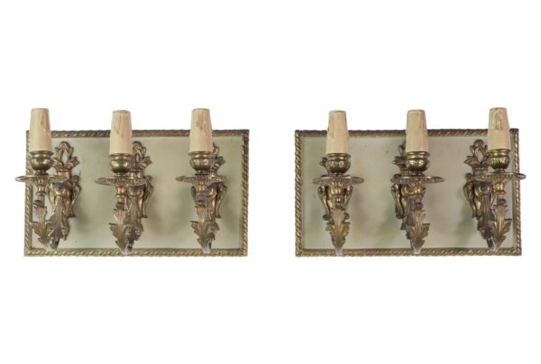 Pair of French-style wall sconces with three brass candlestick arms on each rectangular backplate, shown side by side as a pair.