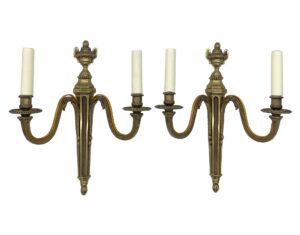 Pair of French bronze double arm wall sconces with urn finials and six candle sockets shown side by side in a matching pair.