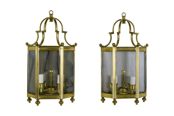 Pair of traditional brass and nickel wall sconces, each with three glass panels and two candle-style lights, shown side by side.