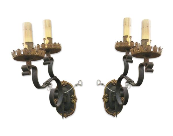 Pair of Tudor-style two-arm wall sconces with wrought iron arms, shown as a matching pair.