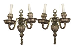 Pair of Georgian style two-arm wall sconces with silver finish and candle-style holders.