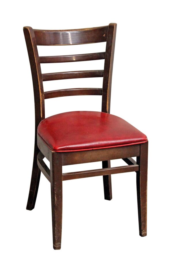 Dark wood tone chair with a red vinyl seat and ladder-style back.