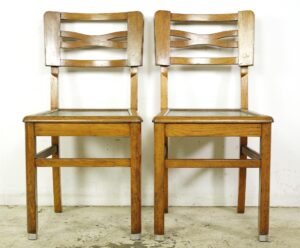 Set of vintage wood dining chairs with green upholstered seats, shown from the back and side to display the rectangular frames and open back slats.
