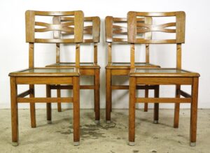 Set of four vintage wood dining chairs with green upholstered seats, shown front view in two rows.