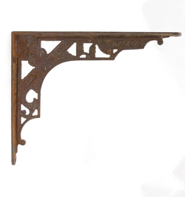 Antique cast iron shelf bracket with ornamental cutout details and a right-angle shape, shown in a single side view.