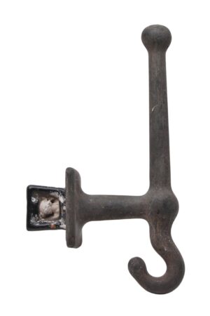Antique cast iron flush mount wall hook with a heavy industrial design and curved hook end.