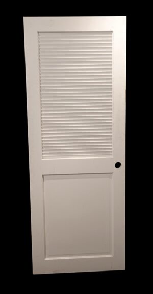 White wooden closet door with one louver panel at the top and one solid panel below, shown frontally with a round hole for hardware.