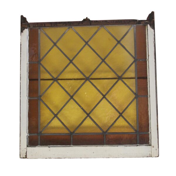 Antique stained glass window with amber and brown panes in a white-painted wood frame, shown front view.