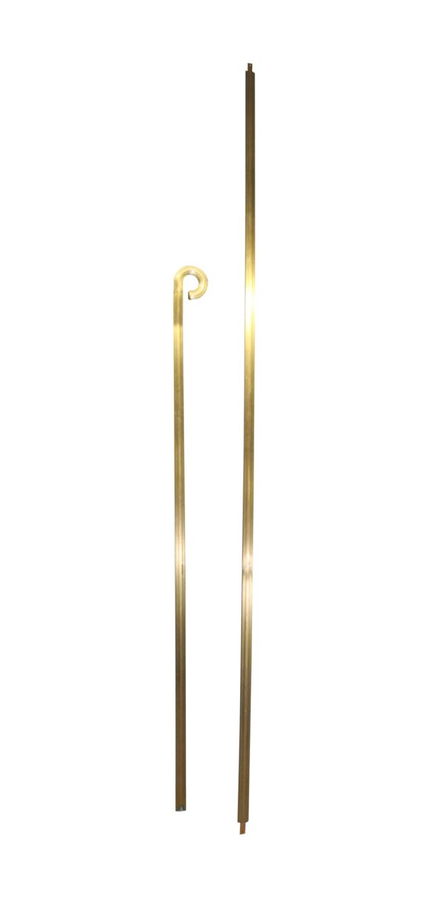 Two-piece stair railing set with one scrolled newel post cap and one long straight rail in polished bronze.