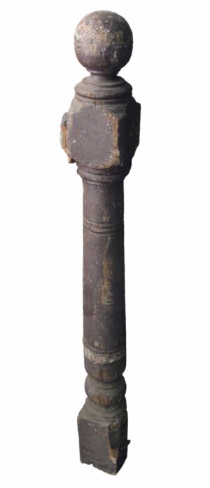 Antique traditional wooden staircase newel post with a carved ball tip and visible wear.