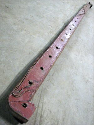 Long reclaimed wooden banister handrail shown at an angle, with evenly spaced spindle holes along the length and a hooked end detail.