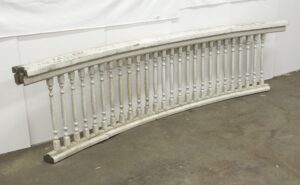 Pair of white curved wooden bannisters with turned spindles and visible age wear, shown together as a matching pair.
