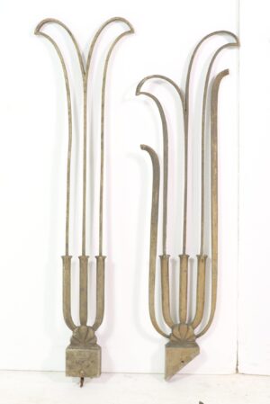Two Art Deco brass balustrades with arched tops and antique patina, shown as decorative railing sections with visible wear and bent parts.