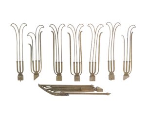 Set of eight Art Deco brass railing balustrades with curved tops and an antique patina, shown with several pieces bent and missing parts, including a few pieces laid horizontally below.