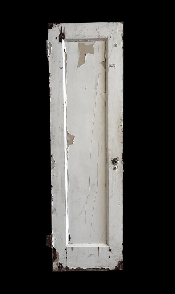 Narrow white wooden passage door with one vertical panel and visible wear, shown with some original hardware attached.