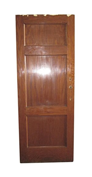 Three-panel oak door with a dark wood tone and recessed panels, shown upright with two lock holes on the right edge.