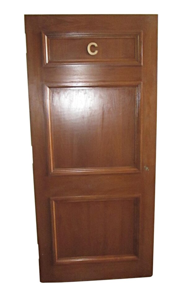 Three-panel wood door with a letter C near the top panel.
