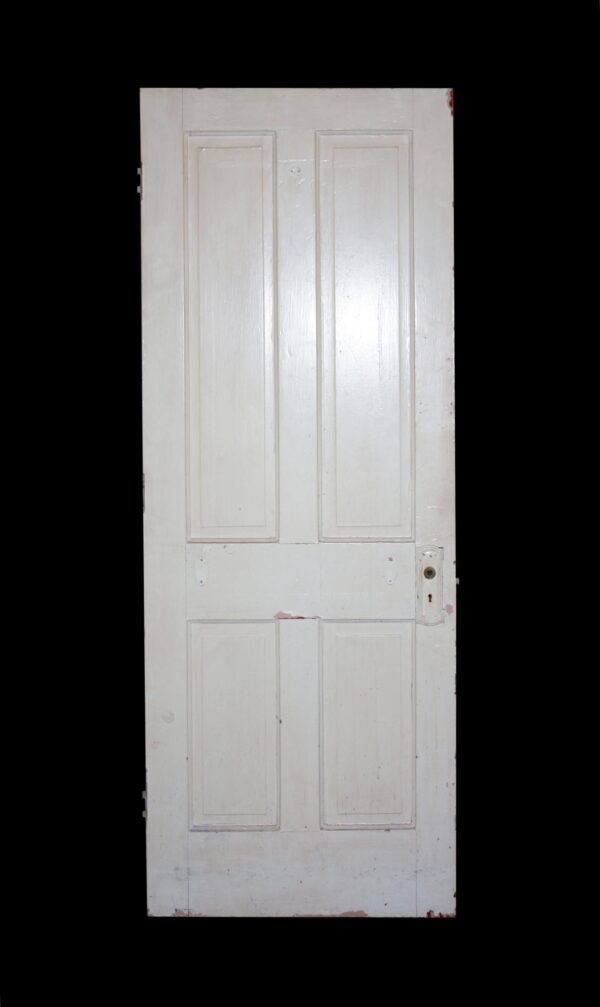 White wood passage door with four vertical panels and a keyhole lock on the right side.