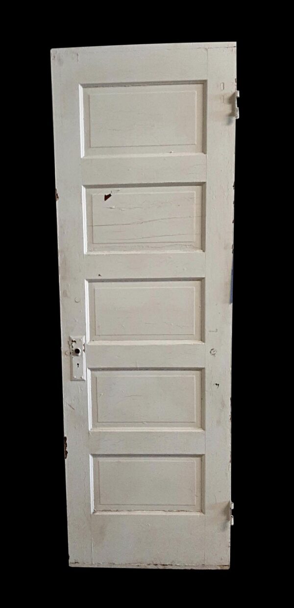 White wooden passage door with five recessed panels and some original hardware attached, shown standing upright and slightly angled.