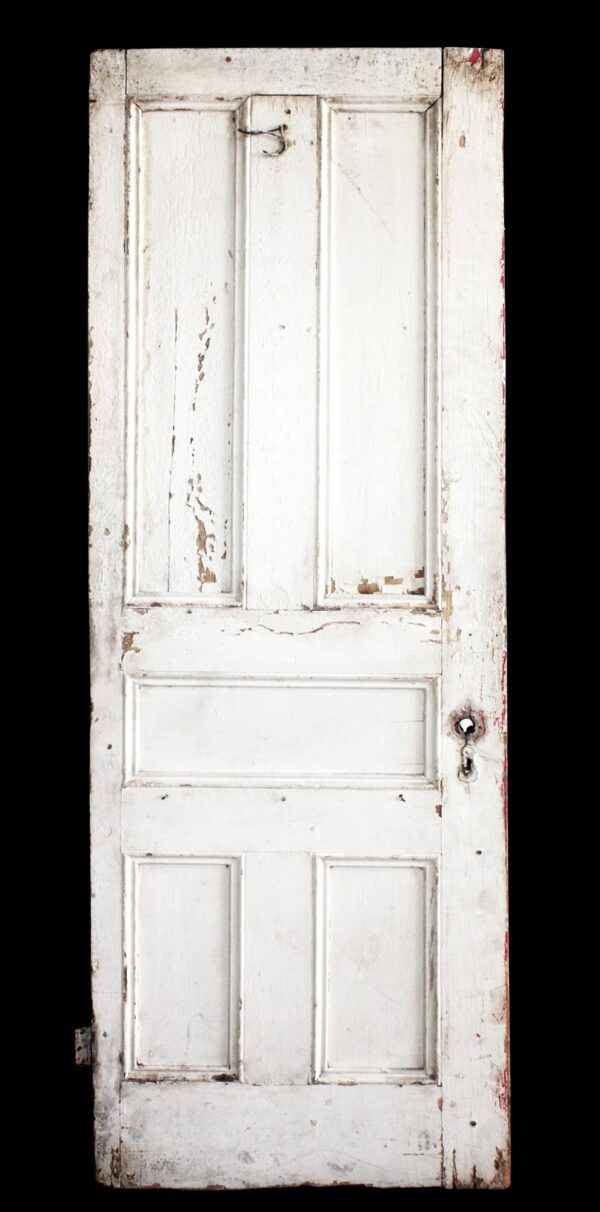 Antique five-panel wood passage door painted white, shown front on with worn paint and a visible hook latch near the top.