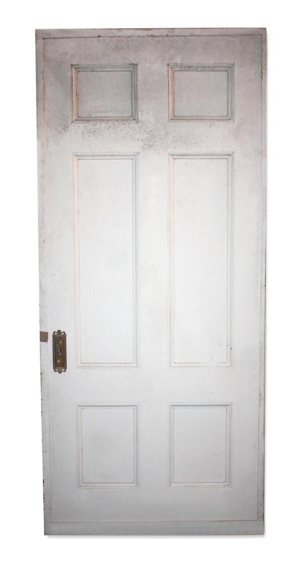 White wood passage door with six recessed panels and an original key plate on the left side.