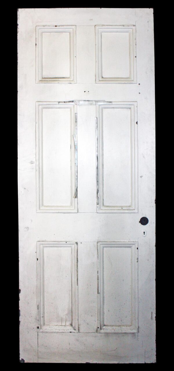 Antique six-panel white wood passage door shown front-on, with three stacked pairs of recessed panels and a plain lower edge.