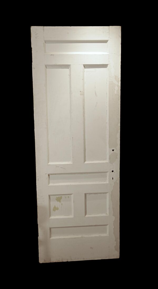 Tall white wooden passage door with seven panels and no hardware attached.