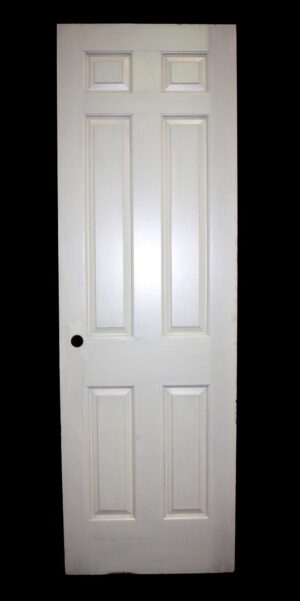 White six-panel passage door shown front-on with raised rectangular panels and a mortise lock hole visible on the left side.