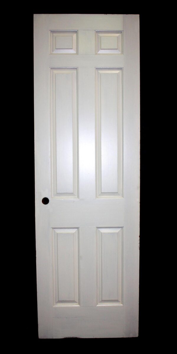 White six-panel passage door shown front-on with raised rectangular panels and a mortise lock hole visible on the left side.