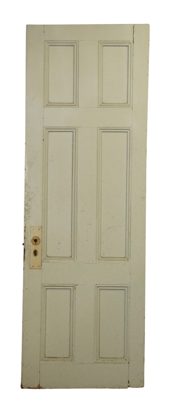 Six-panel wooden door with visible lock hardware and worn paint.