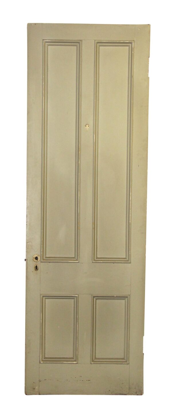 Tall narrow white wooden door with four recessed panels and a keyhole near the left edge.