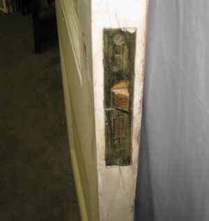 Close-up of a white wood passage door showing the latch mortise and edge hardware cutout.