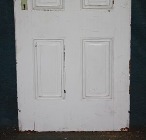 White four-panel passage door shown front-on, with worn paint and no hardware visible.