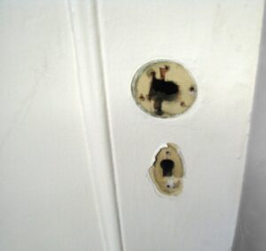 Close-up of a white wooden passage door showing the keyhole and round lock opening.