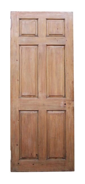 Vintage pine door shown with the six-panel side facing forward and a medium wood tone.